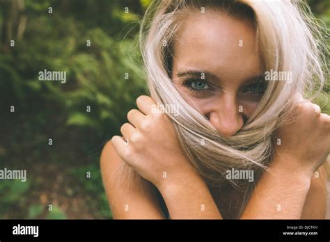 Happy Gorgeous Blonde Covering Her Mouth With Hair Stock Photo Alamy