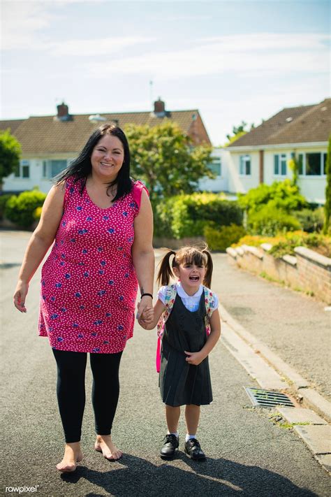 Mother walking her daughter to the school bus | premium image by
