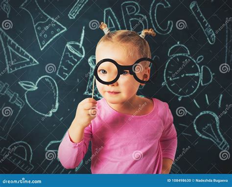 Pretty Small Girl Investigate Something Through Glasses On Chalk Stock