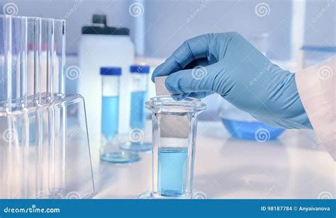 Scientific Or Medical Background With Gloved Hand Holdong Micros Stock