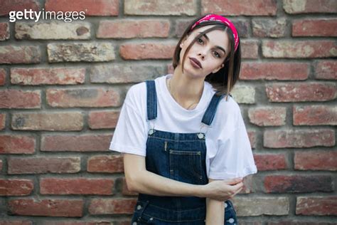 Slim Sexy Brunette Girl Wearing Woman S Denim Overall Over Green Tree
