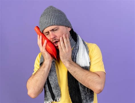 Douleur jeune homme slave malade blonde portant un chapeau d hiver et une écharpe Photo Gratuite