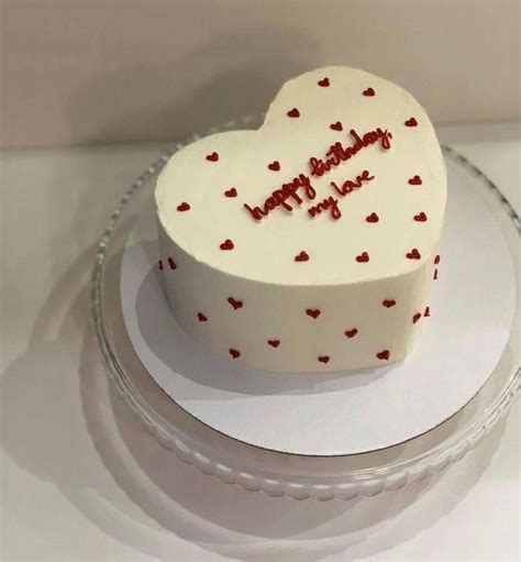 A Heart Shaped Cake With The Words Happy Birthday On It Sitting On A