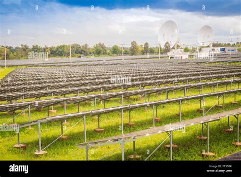 Large Scale Solar Farm With The Satellite Dishes Under Dramatic Blue