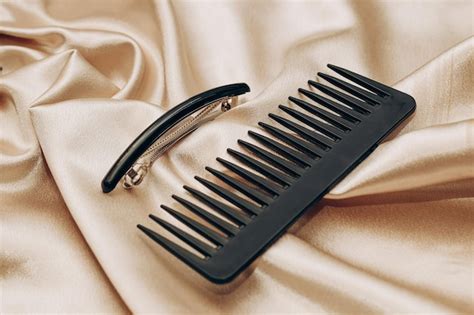 Premium Photo | Elegant black hair clip and comb on a silk golden ...