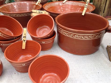 Many Clay Pots Are Lined Up On A Table With Clothes Pins Stuck To The