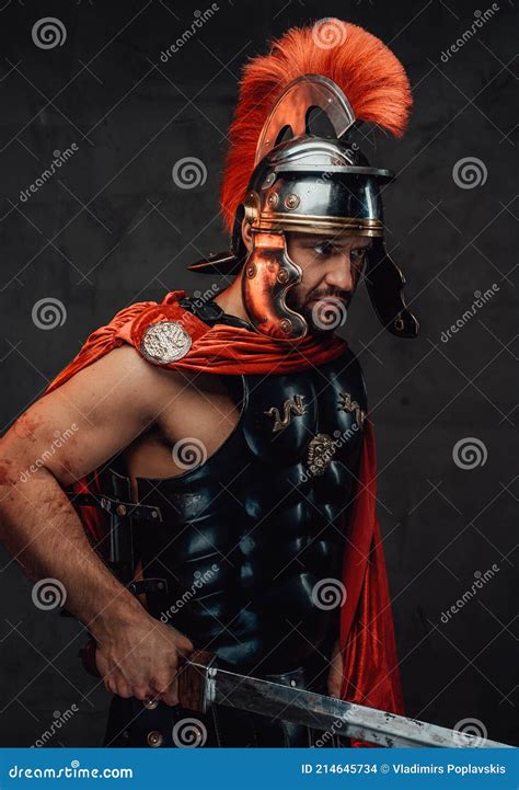 Roman Soldier With Red Mantle And Armour Posing With Sword Stock Photo