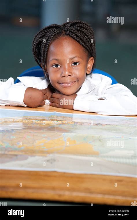 Retrato De Chica Sentada En La Mesa Con El Mapa Del Mundo En El Aula