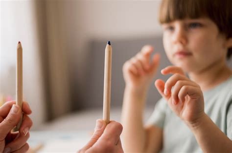 Vista lateral del niño desenfocado que recibe tutoría en casa Foto Gratis