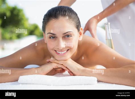Smiling Brunette Enjoying A Massage Poolside Stock Photo Alamy