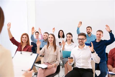 People Raising Hands To Ask Questions At Business Training Stock Photo