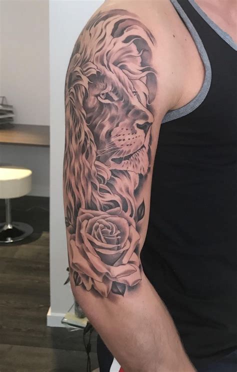 A Man With A Lion And Roses Tattoo On His Arm