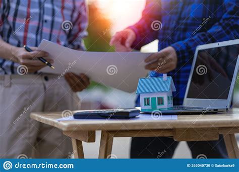 Engineer Pointing At Blueprint And Using Laptop To Draw Building Design