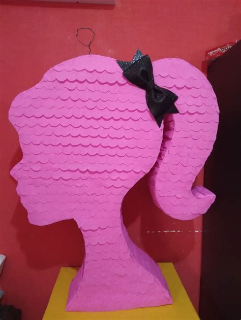 A Large Pink Sculpture With A Black Bow On It S Head In Front Of A Red Wall