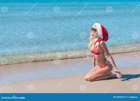 Mooie Blondevrouw In Rode Kerstmishoed En Bikini Op Overzees Strand