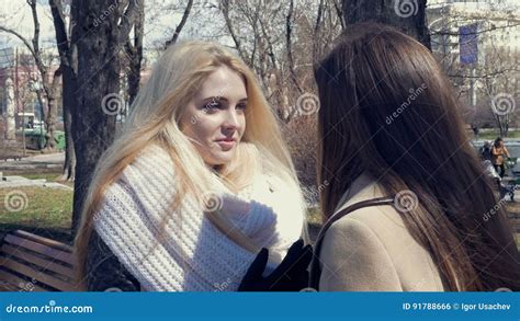 Deux Belles Filles Sexy Blonds Et Brune Parlant En Parc Conversation