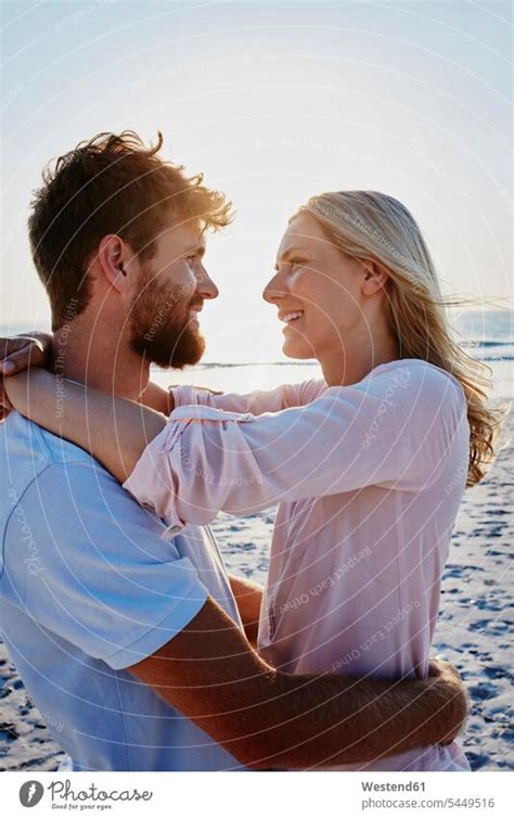 Smiling Couple Hugging On The Beach At Sunset A Royalty Free Stock