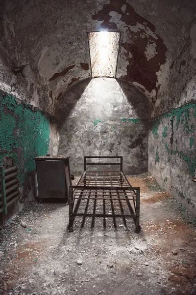 Abandoned prison cell walkway with old rusty stairs, doors and peeling ...