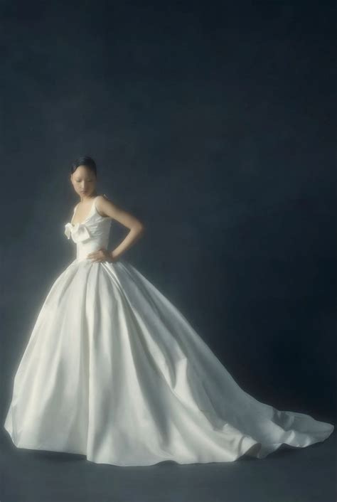 A Woman In A White Wedding Dress Standing With Her Hands On Her Hips