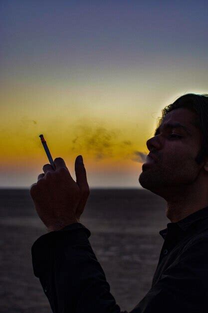 Premium Photo Man Smoking Cigarette Against Sky During Sunset