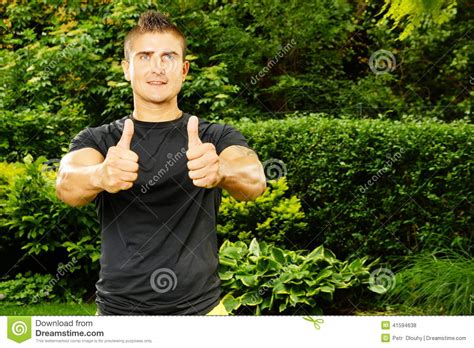 O Homem Na Camisa Preta Mostra O Polegar Acima Foto De Stock Imagem