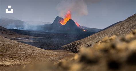 A Volcano Spewing Out Lava In The Distance Photo Free Iceland Image