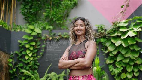 Confident Multiethnic Woman In Sportswear Stands In Urban Green Space