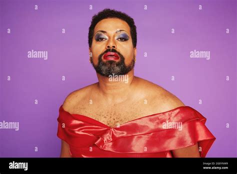 Portrait Of A Man With Beard Wearing Red Female Dress And Makeup