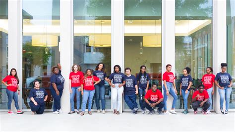 A Large Group Of Students In Dark Blue Or Red T Shirts Smiling In Front