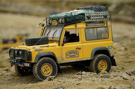 A Yellow Toy Truck In The Sand With Some Tires On It S Back End