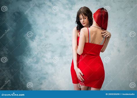 A Close Up Portrait Of Two Tenderly Embracing Women Dressed In