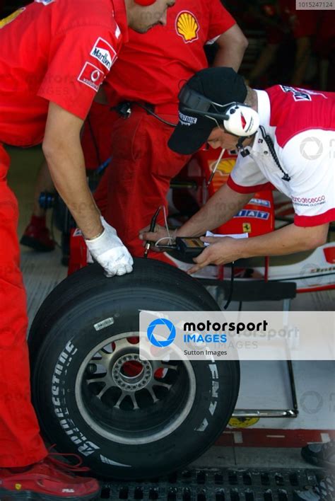 A Bridgestone Technician Check The Tyre Temperature Of A Ferrari Tyre