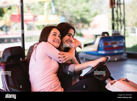 Two Young Women Having A Fun Bumper Car Ride At The Amusement Park