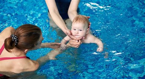 Adorable bebé disfrutando de nadar en una piscina infantil con su madre