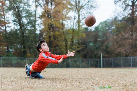 "Young Boy Playing Football On A Practice Field" by Stocksy Contributor ...