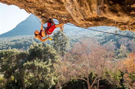 Girl Climber On An Overhanging Rock A Sports Woman Climbs A Rock