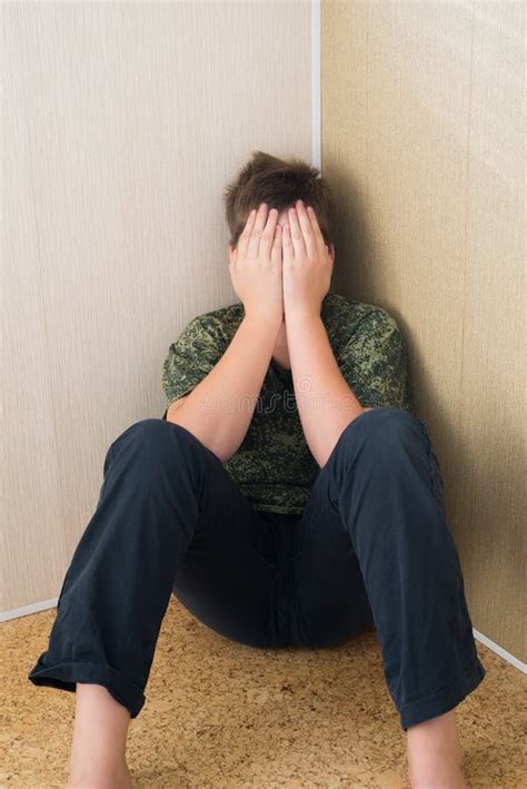 Boy Teenager With Depression Sitting In The Corner Of Room Stock Image