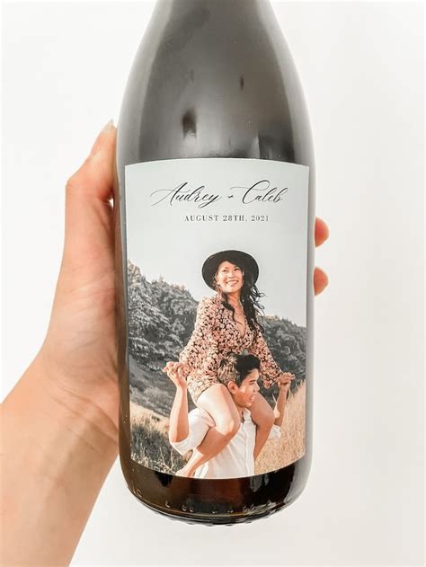 A Hand Holding A Bottle Of Wine With An Image On The Front And Back Of It