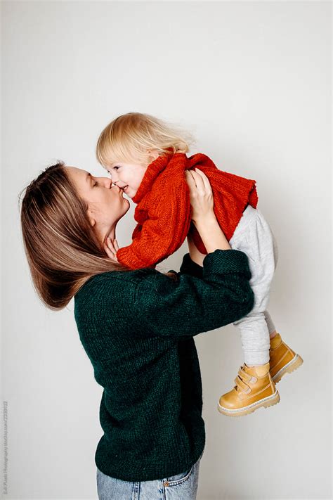 Mum Holding And Kissing Her Sun At Home During Christmas Holidays By Stocksy Contributor