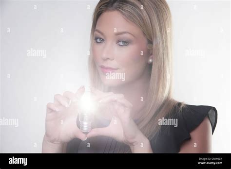 Beautiful Woman Holding Up A Light Bulbs In Her Hand With The Bulb