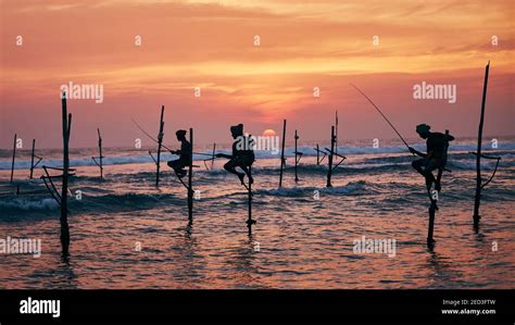 Silhouettes Of Three Fishermen At Beautiful Sunset Traditional Stilt