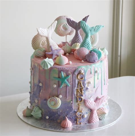 There Is A Cake Decorated With Sea Shells On The Top And Bottom Along With Seashells