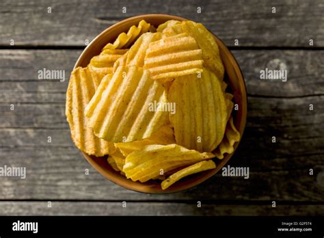 Crinkle Cut Potato Chips On Kitchen Table Tasty Spicy Potato Chips In