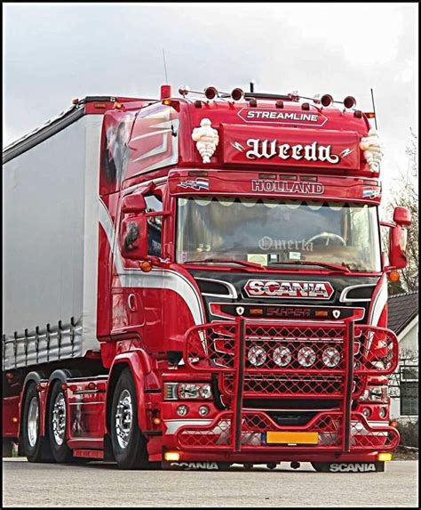 A Red Semi Truck Driving Down A Street