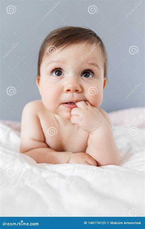 Portrait Of Beautiful Baby Lying On Stomach And Looking At Camera