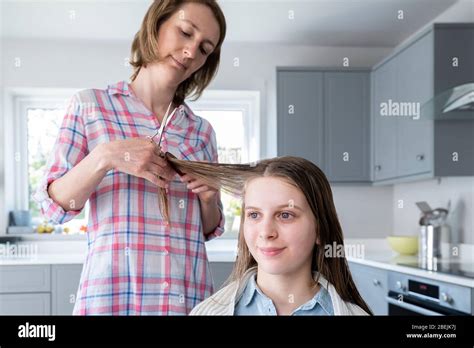 Mother Cutting Teenage Daughters Hair At Home During Lockdown Stock