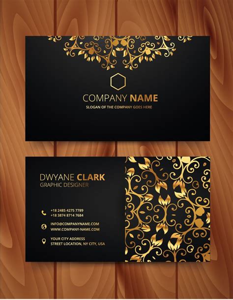 two black and gold business cards on wooden background with floral ...