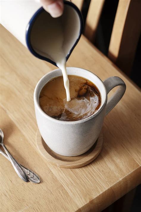 Coffee Cup Pouring Milk In Coffee Mug Morning Hot Drink Stock Photo