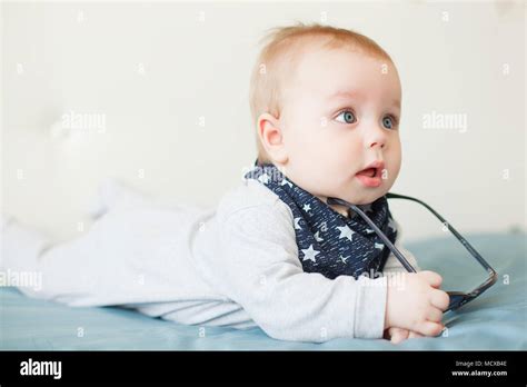 Little Funny Baby Boy With Big Blue Eyes And Sunglasses On His Head