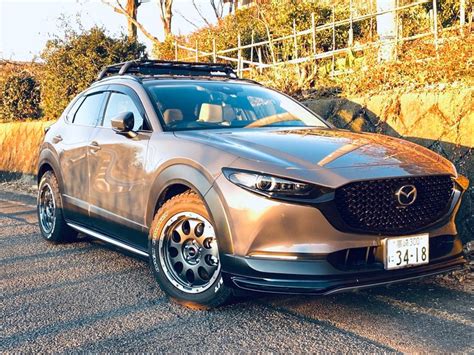 a silver mazda cx - 5 parked on the side of the road in front of some ...